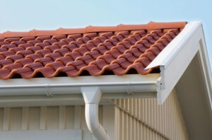 Close up of a red tile roof with a white gutter